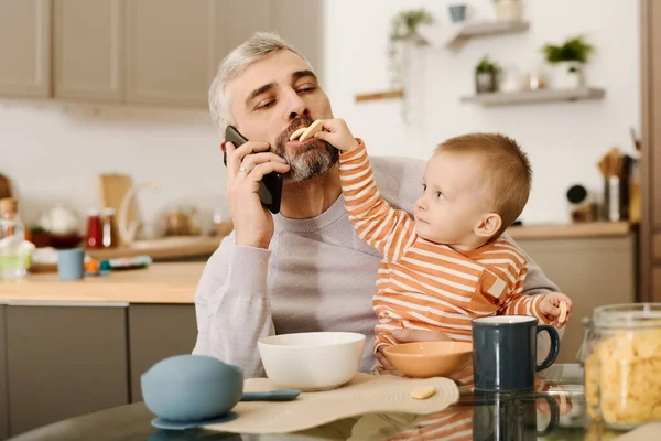 Adorable Baby Putting Small Tasty Biscuits Mouth Busy Father Holding — Stock Photo, Image