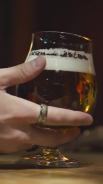 Tanımlanamayan barmenlerin dikey yakın çekimi Aziz Patrick Günü 'nde barda kimliği belirsiz müşterilere bir bardak filtrelenmiş bira, bira ya da bira servis ediyor.