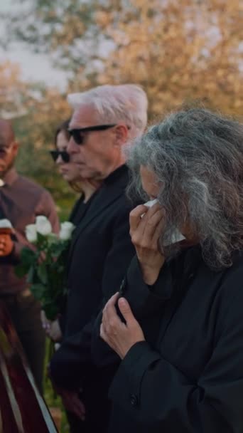 葬儀中の墓地で静かに泣いている白人高齢女性の垂直側の映像 — ストック動画