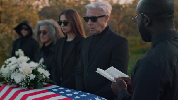 Siyah Rahibin Amerikan Askeri Kafkas Ailesinin Mezarlıktaki Tahta Tabutun Yanında — Stok video