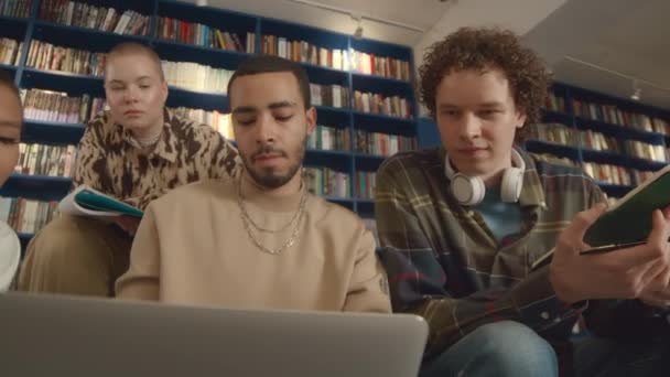 Üniversite Kütüphanesinde Birlikte Oturan Dört Farklı Genç Öğrencinin Orta Kavisli — Stok video