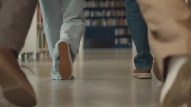 클로즈업 캐주얼 청바지와 신발에 익명의 젊은이의 다리의 도서관을 바닥에 공부를위한 — 비디오
