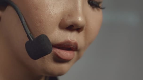 在官方活动或会议上 带着耳机在舞台上对着话筒讲话的年轻亚洲女人的宏观照片 — 图库视频影像