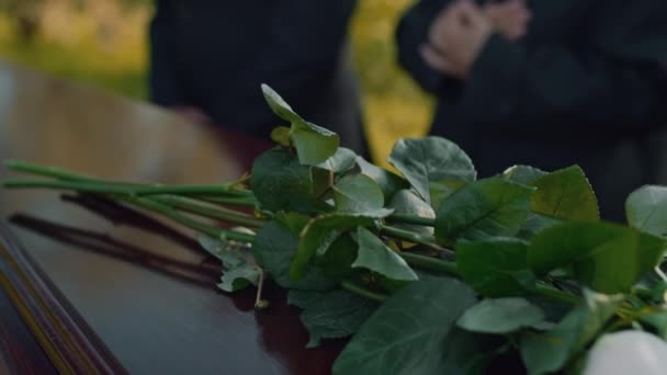 Zbliżenie Czterech Białych Kwiatów Róż Leżących Pokrywie Drewnianej Trumny Podczas — Wideo stockowe