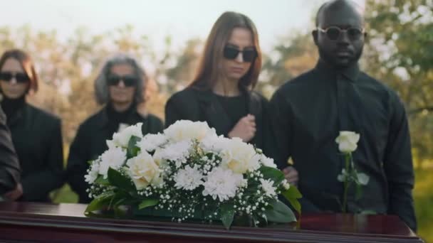 Ręczne Zbliżenie Białej Róży Kwiatów Stokrotki Drewnianej Pokrywie Trumny Żałobnikami — Wideo stockowe