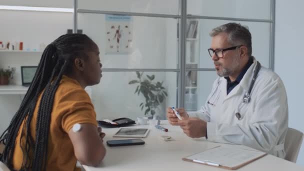 Medium Shot Middle Aged Male Doctor Consulting Young African American — Stock Video