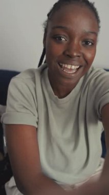 Genç Afrikalı Amerikalı kadının akıllı telefondaki blog için video kaydederken, konuşurken, yeni glikoz izleme cihazını gösterirken ve onun faydalarını ve kolaylığını tanıtırken orta boy dikey selfie çekimi.