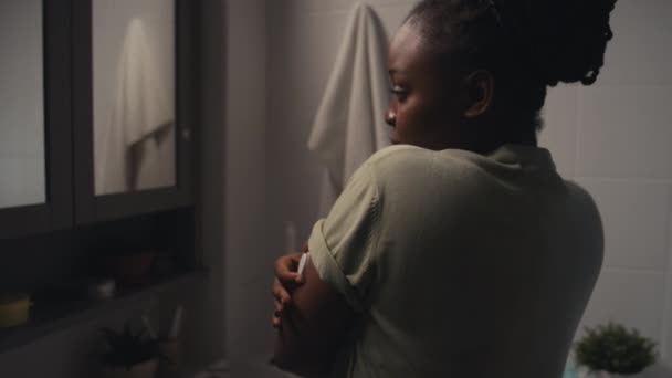 年轻的非洲裔美国女性糖尿病患者站在浴室里 照镜子研究新的葡萄糖检测装置的中等后拍照片 — 图库视频影像