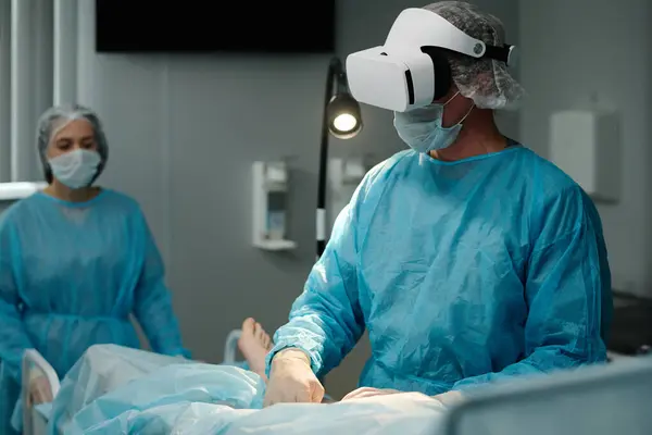 外科手术时戴Vr耳机 防护面罩和手套的内科医生 — 图库照片