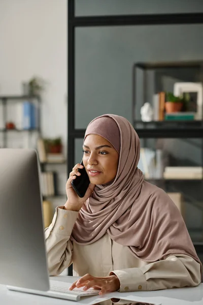 Manager Musulmana Hijab Tenendo Smartphone Orecchio Mentre Seduto Davanti Computer — Foto Stock