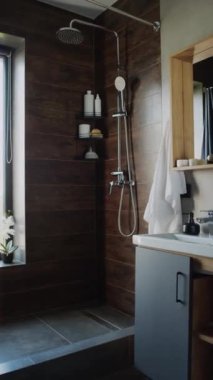 Modern apartmanda ya da evde, kapısız duşlu, kahverengi ahşap panelli, leğenli, aynalı ve pencereli orkideli şık minimalist banyodan çekilen insanlar yok.