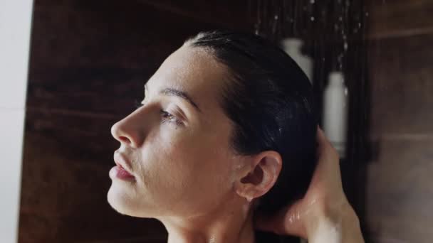 코카서스 소녀의 얼굴의 클로즈업 샤워에서 흐르는 머리를 헹구고 부드러운 스트로킹 — 비디오