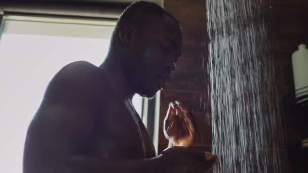 샤워에서 흐르는 아프리카계 선수의 클로즈업 손바닥에 비누를 — 비디오