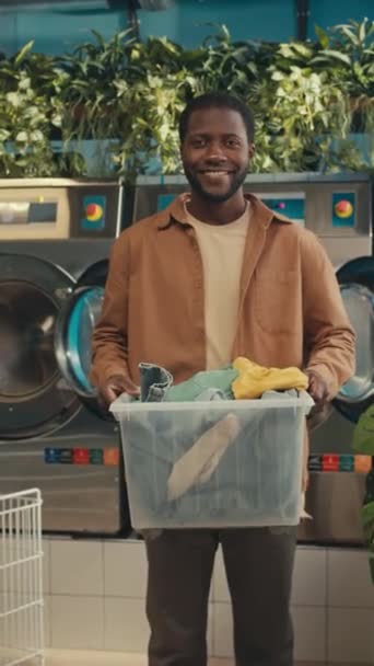 Vertikální Dolly Zoom Usmívající Afroameričan Chlap Drží Plastový Koš Barevných — Stock video