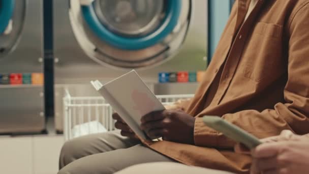 Afro Amerikan Bir Adamın Koltukta Oturup Halka Açık Çamaşırhanede Telefonla — Stok video