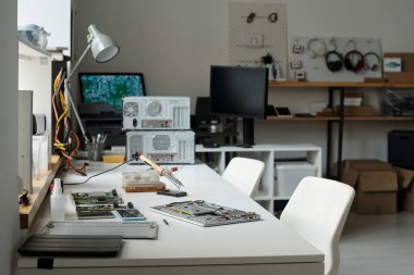 Geniş ofisteki onarım servisi teknisyeninin çalışma yerinde ya da masalarla modern çalışma alanında parçalanmış dizüstü bilgisayar