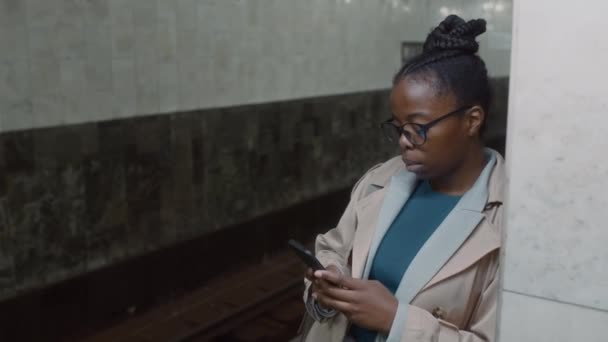 Zdjęcia Poboczne Poważnej Afroamerykanki Okularach Smsującej Wiadomości Smartfonie Opierając Się — Wideo stockowe