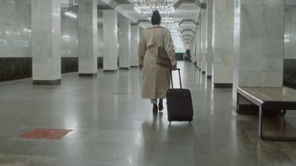 여행하는 수하물과 지하철 플랫폼을 트렌치 코트에서 식별되지 여자의 동영상 — 비디오