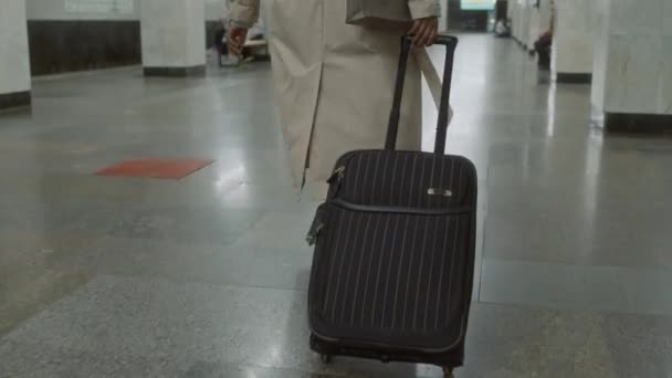 Trençkotlu Kimliği Belirsiz Bir Kadınının Yer Altında Siyah Çizgili Bavuluyla — Stok video