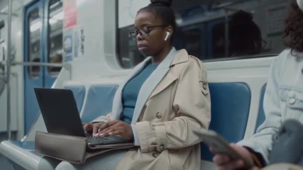 アフリカ系アメリカ人のフリーランサーが地下鉄の列車で長距離走行中にラップトップで作業する様子 — ストック動画