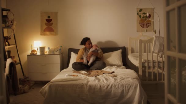 따뜻한 카디와 피자마에 아프리카계 미국인 히스패닉 어머니의 저녁에 집에서 침대에 — 비디오