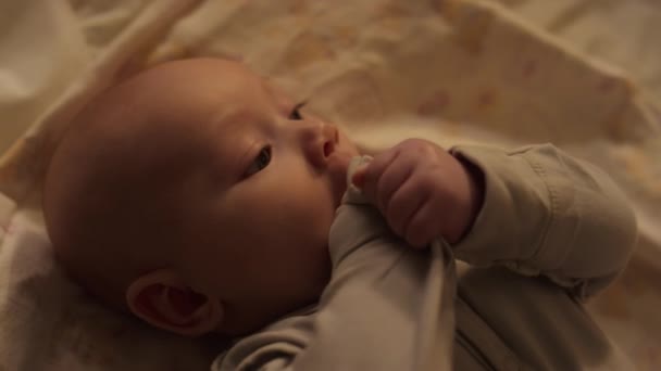 Aylık Erkek Bebeğin Yatak Çarşafında Sırt Üstü Yatıp Etrafa Bakınırken — Stok video