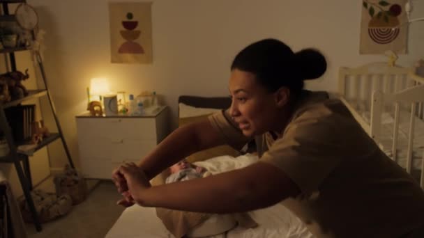 아들이 침대에 코쿤에 누워있는 집에서 운동하는 쾌활한 긍정적 어머니의 구부리는 — 비디오