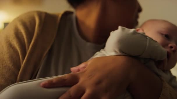 ロックしている母親の腕の4ヶ月の赤ん坊の顔のクローズアップショット 彼を抱きしめ ナプキンで濡れた口を拭き 何かの間に落ち着いた — ストック動画