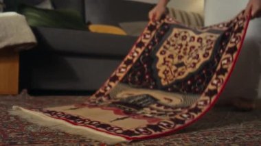Beyaz elbiseli, tanınmayan Müslüman bir kadının evde namaz kılmadan önce paspası yere serip üzerine basarak ezdiği zemin kattaki görüntüler.