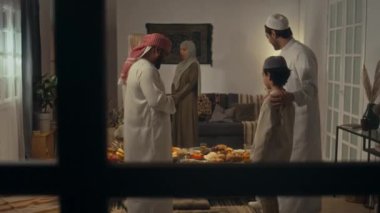 Müslüman ailenin Uraza Bayram 'da toplanıp bayram yemeği yediği tam bir pencere görüntüsü.