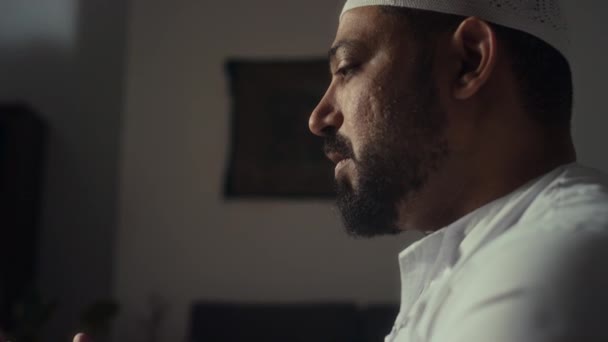 집에서 무릎에 기도를 무슬림 두개골 모자에 Biracial 수염된 남자의 클로즈업 — 비디오