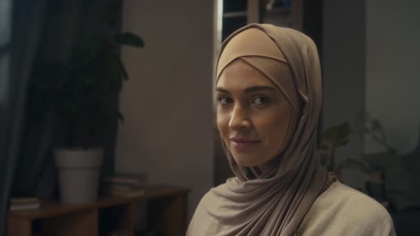 집에서 기도하고 카메라를보고하기 바닥에 가벼운 히잡으로 코카서스 무슬림 숙녀의 초상화 — 비디오