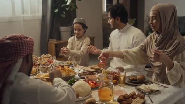 イスラム教徒の家族のメディア映像が集まり 自宅で豊富なお祝いのテーブルでイードアルフィトルの休日を祝いました — ストック動画