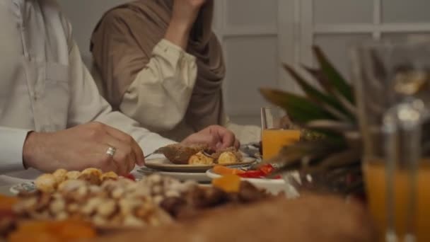 サイドは 匿名の妻と夫が自宅でジャガイモとパンを持っているEid Fitrでお祝いの夕食を持っている映像を収録しました — ストック動画
