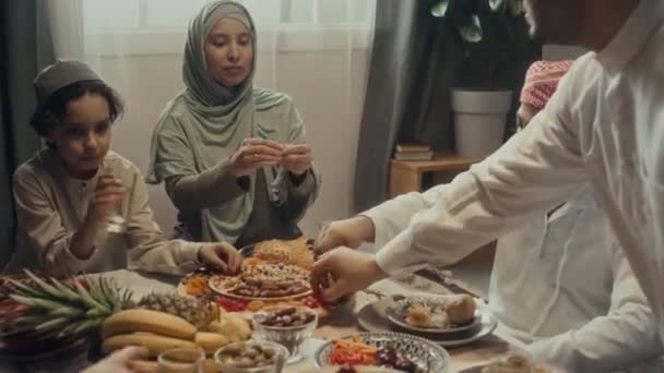 在庆祝开斋节的餐桌前 穆斯林家庭成员都在家中吃着坚果和干果 一边一边聊天 一边手拿着镜头 — 图库视频影像