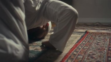 Gözlemci Müslüman adamın Allah 'a dua ettiği ve evde şükranlarını sunduğu arka zemin seviyesindeki görüntüler.