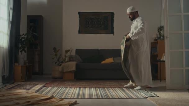 Thobe에서 종교적인 남자의 동영상 바닥에 매트를 거실에서 일어나 — 비디오