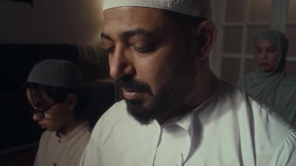 在家里打盹的时候 一个虔诚的穆斯林男子悄悄地朗诵 古兰经 他的妻子和儿子都在听 — 图库视频影像