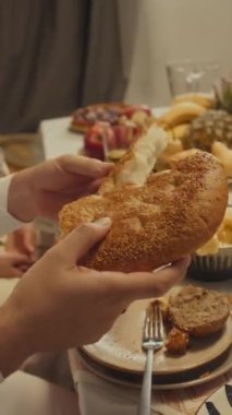 Evde bayram kutlamaları sırasında aile üyeleriyle yassı ekmek ya da pide paylaşan tanınmamış müslüman adamın yan görüntüleri.