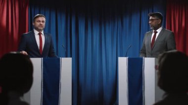 Seçim tartışmalarına katılan iki Amerikalı politikacının orta boy çekimi - Kafkas erkek çoğunluk lideri ekonomi politikasını özetliyor, ve Hintli muhalefet adayı onu eleştiriyor ve ona meydan okuyor