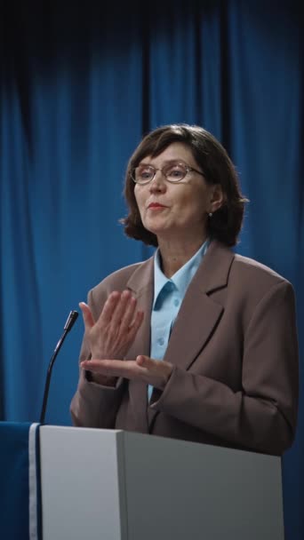 中年白人女性候选人竞选市政选举市长的中垂直镜头 戴着眼镜 在公共辩论中对社会问题给出了坦率的意见 — 图库视频影像