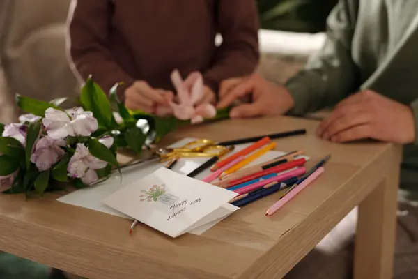 手工制作的明信片 上面放着一束鲜花 上面贴着小男孩 帮助他的父亲用缎带扎花 — 图库照片