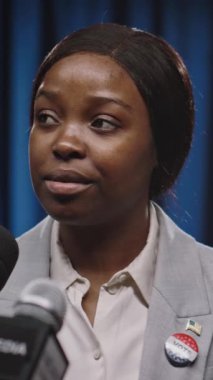 Başkanlık seçim kampanyası sırasında kitle iletişim araçlarının sorularını cevaplayan genç Afrikalı Amerikalı kadın basın sözcüsü ya da kongre adayının orta boy dikey çekimi