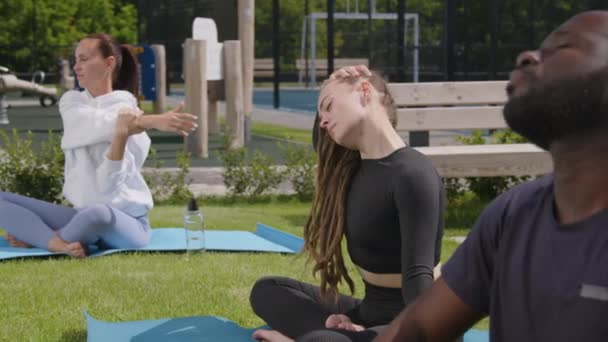 Aktif Kıyafetli Kadın Erkeğin Bahçedeki Çimenlikte Yoga Minderleri Üzerinde Otururken — Stok video