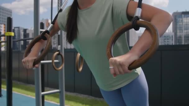 美しい街並みで屋上スポーツグラウンドでプッシュアップを実行するためのロマンチックなリングを使用して笑顔のコーカサス女性のサイド傾き — ストック動画