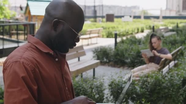Boczne Nagranie Afroamerykanina Okularach Stojącego Dachu Pracującego Online Laptopie — Wideo stockowe