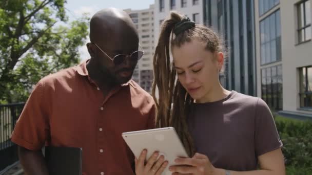 Farklı Erkek Kadın Arkadaşlarının Şehir Parkında Dikilip Dijital Tablete Bakarak — Stok video