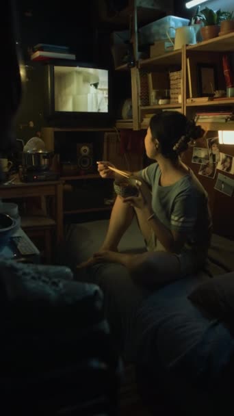 Полный Вертикальный Снимок Молодой Азиатки Сидящей Скрещенными Ногами Кровати Загроможденной — стоковое видео