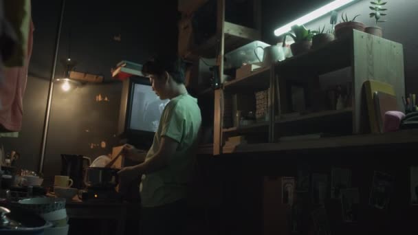 Pełne Ujęcie Młodego Chińczyka Stojącego Ciemnym Nędznym Mieszkaniu Mieszającego Jedzenie — Wideo stockowe