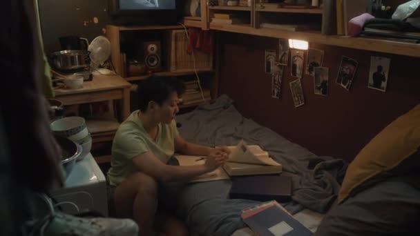 마이크로 아파트에서 바닥에 아시아 남자의 교과서를 복사본에서 노트를 만드는 숙제를하거나 — 비디오
